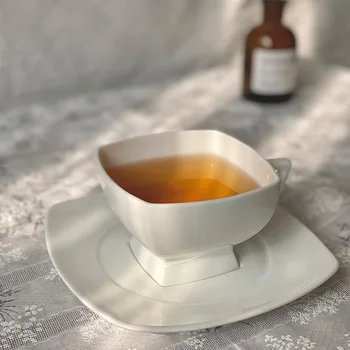 Amerikos keraminės kavos puodelis ir lėkštelė vaiskiai balta kaulų kinija, viduramžių taurės anglų popietės arbata, kavos puodelis ir lėkštelė